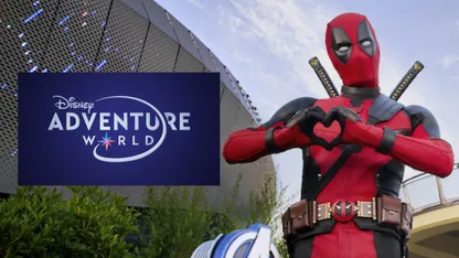 Deadpool poses beside a sign for Disney Adventure World.