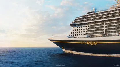Disney cruise ship sailing across the ocean at sunset, with “Disney BELIEVE” on its hull.