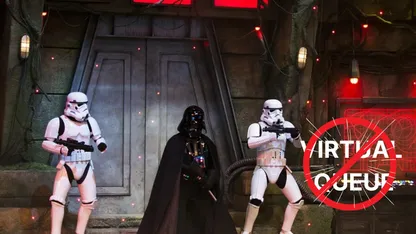 Darth Vader and two stormtroopers stand in front of a door with a red sign