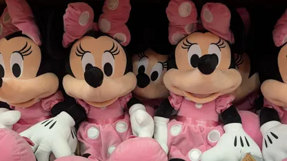 Rows of Minnie Mouse plush toys wearing pink dresses and bows.