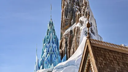 A blue castle with a tower and a mountain covered with snow