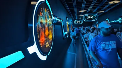 People in the queue for TRON inside with signage on the walls