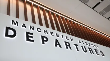 Manchester Airport Departures sign with a modern design and lighting