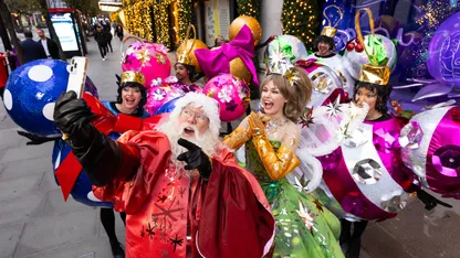 A group of people dressed as Christmas characters are posing for a photo