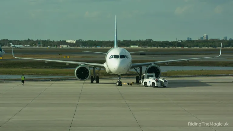 Passenger jet being towed on the runway with a ground vehicle in front