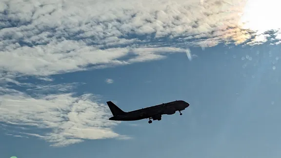 Aircraft approaching to land against a cloudy sky