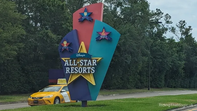 Disney’s All-Star Resorts entrance sign beside a yellow taxi.