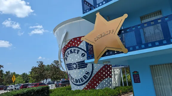 Film-themed building exterior with a large gold sheriff’s star and rocket emblem.
