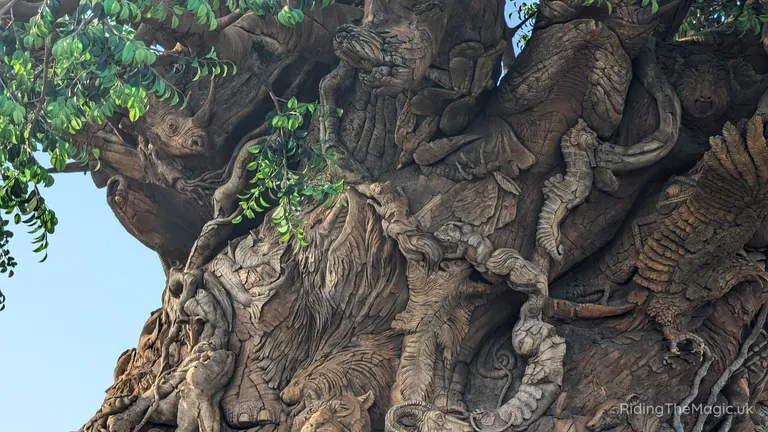 Intricately sculpted tree of life trunk covered with carved animal and human-like figures, twisting roots and foliage.
