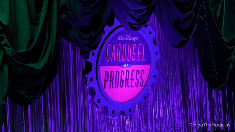 Walt Disney’s Carousel of Progress sign on a purple stage curtain backdrop