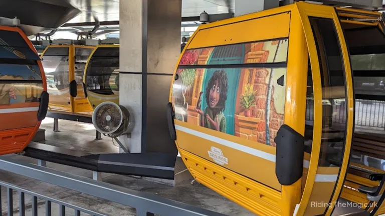 Yellow Disney Skyliner car cabins at a station platform
