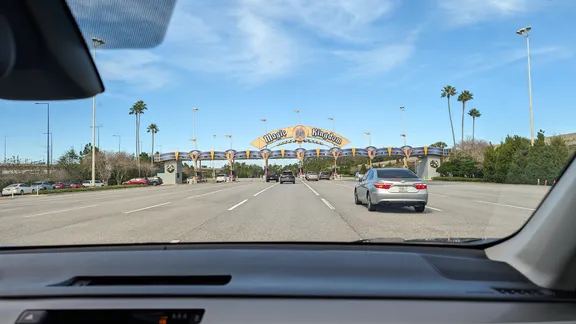 Road approaching the Magic Kingdom entrance beneath a blue sky.