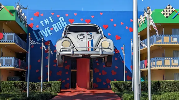 Volkswagen Beetle mounted on a blue mural wall with red hearts and the words “The Love Bug”.