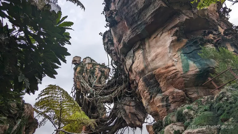 Massive weathered rock formations covered with vines and tropical vegetation.