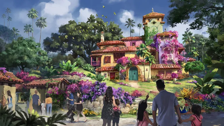 A colorful Mediterranean-style villa surrounded by lush tropical gardens and visitors under a bright blue sky.