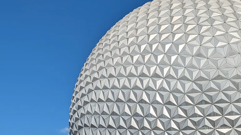 Close-up of Spaceship Earth’s geodesic dome at EPCOT against a clear blue sky.
