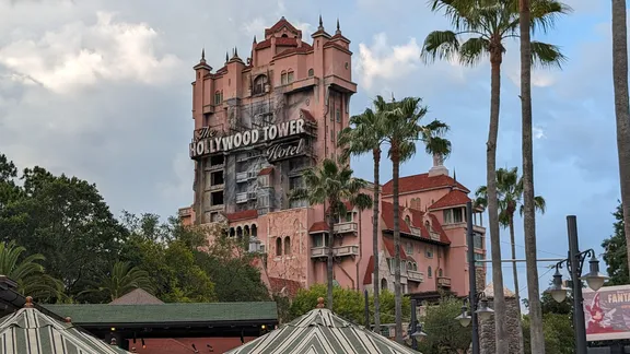 The Hollywood Tower Hotel attraction, surrounded by palm trees and other theme-park buildings.