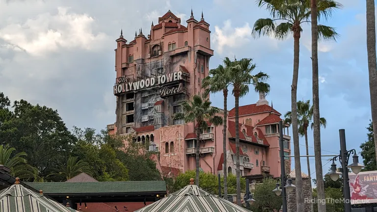 The Hollywood Tower Hotel attraction, surrounded by palm trees and other theme-park buildings.