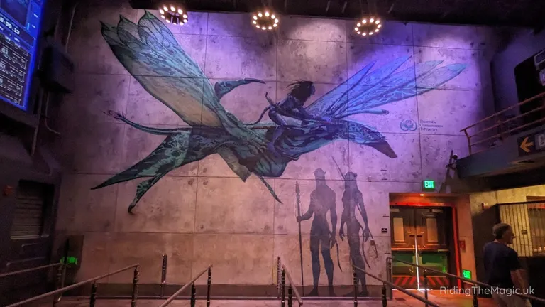 Wall mural depicting a winged creature and silhouetted figures in a dimly lit, purple-lit interior.
