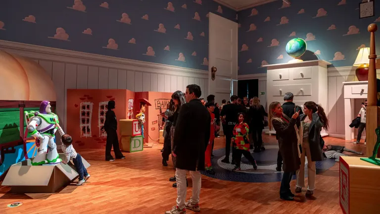Museum gallery with visitors viewing an exhibition, featuring a globe, red display cabinet and astronaut figure.