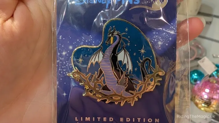 Limited-edition enamel pin featuring a winged dragon surrounded by stars and ornate golden detailing.