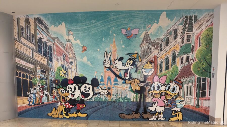 A mural of Mickey and Minnie Mouse and other Disney characters in front of buildings