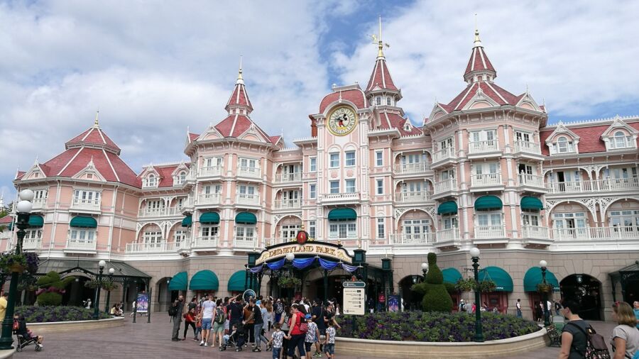 Entrance to Disneyland Paris with a large clock tower and Mickey Mouse on the clock
