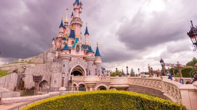Disney castle with blue sky and clouds in the background