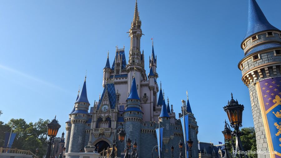 A blue and white castle with a clock tower in the middle of a park