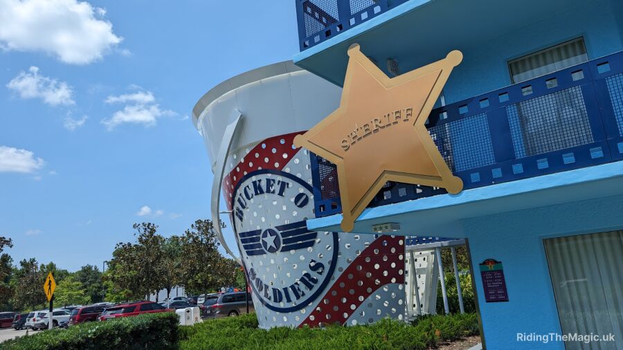 A blue building with a sheriff star and Bucket O Goodies logo on the side
