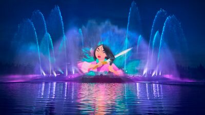 A nighttime show featuring a projection of Mulan on a lake with water fountains