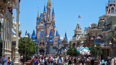 Disney World's Cinderella Castle with a crowd of people walking around in the foreground