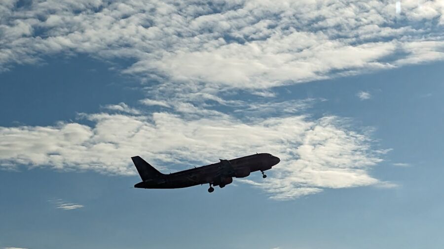 An airplane is flying in the sky with clouds