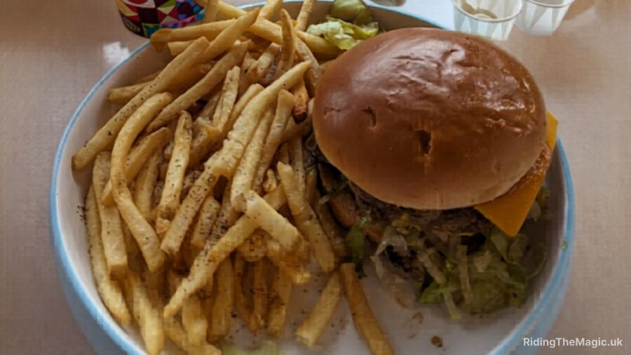 A burger with fries and a side of lettuce on a white plate