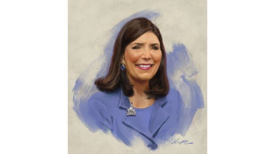 Portrait of a smiling woman wearing a blue blazer with a Disney Castle pin