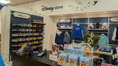 Disney store with merchandise including mugs, clothes, and toys on display