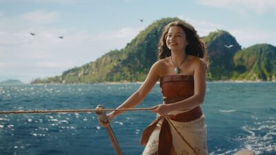 Moana standing on a boat holding a rope with a smile on her face