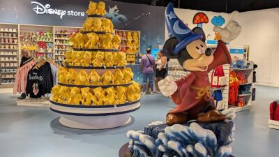 A Disney store with Mickey Mouse statue and yellow teddy bears on display