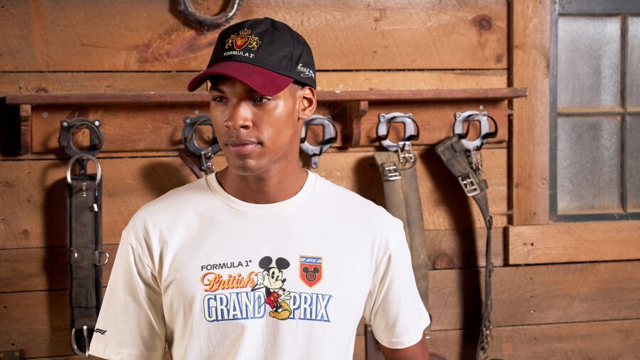 A man wearing a Formula 1 Mickey Mouse T-shirt and a cap