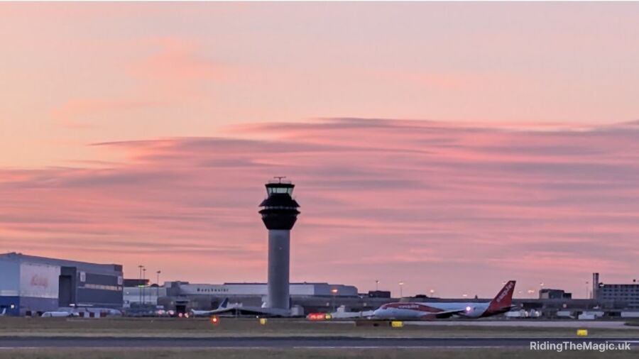 A plane is parked on the runway at an airport during sunset