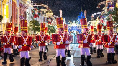 Toy soldiers marching in a parade on a street decorated for Christmas