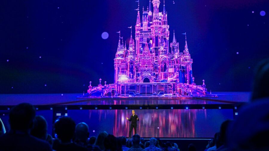 A man on stage with a pink castle behind him
