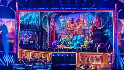 A stage with a large screen showing animated characters and a crowd watching