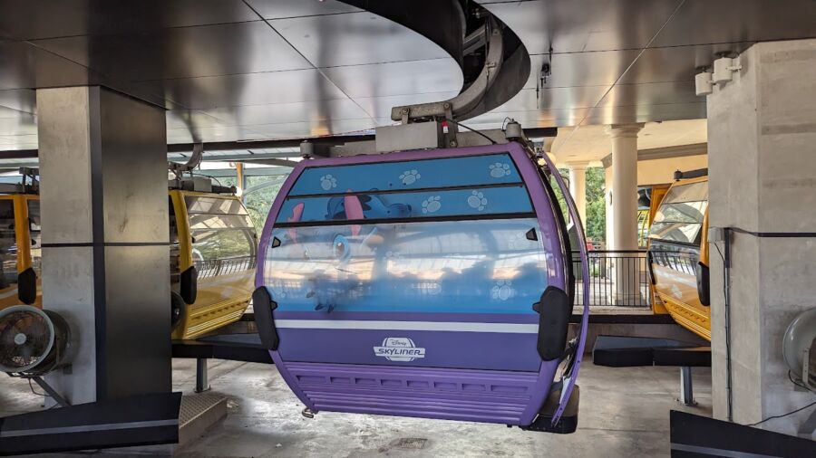 A purple gondola car from the Disney Skyliner ride with a blue cartoon character on it