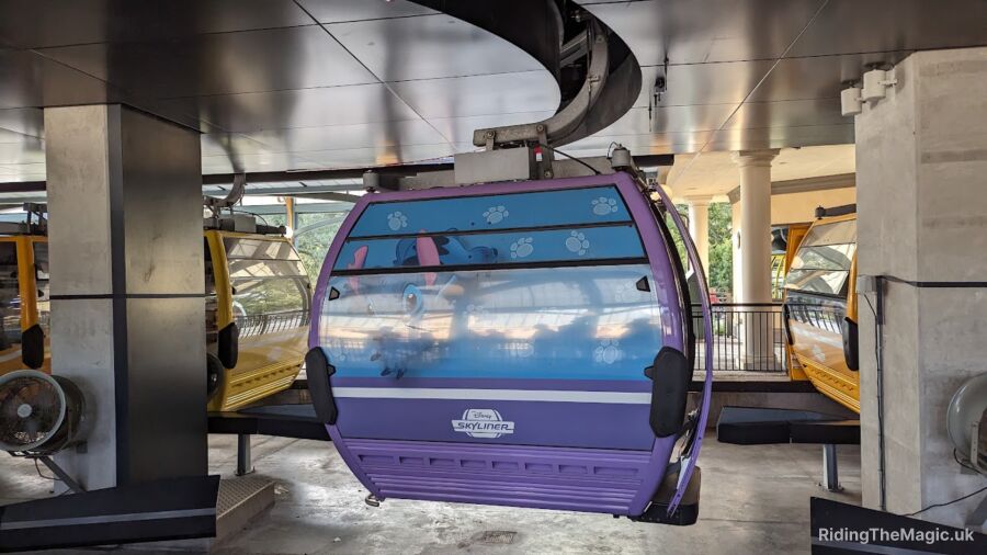 A purple gondola car from the Disney Skyliner ride with a blue cartoon character on it