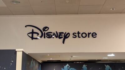 A sign for a Disney store on the wall of a building