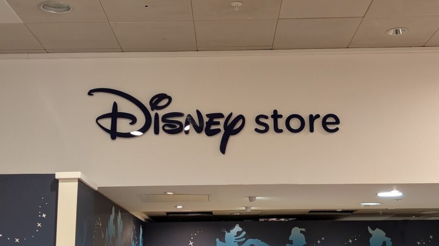 A sign for a Disney store on the wall of a building