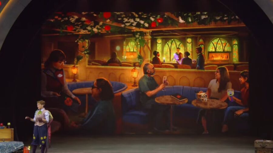 People sitting at tables in a restaurant with a projection of a Christmas scene