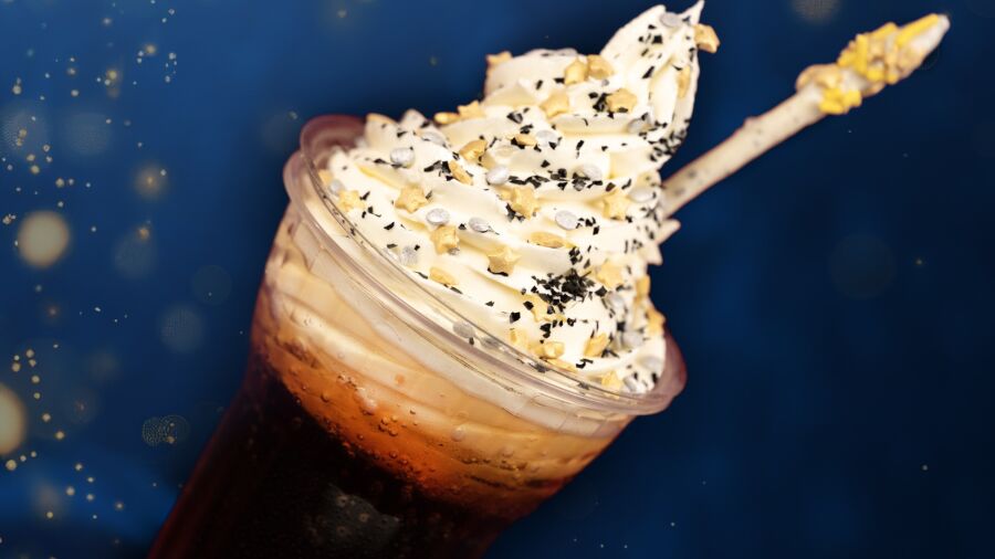 A cup of coffee with whipped cream and chocolate sprinkles on top