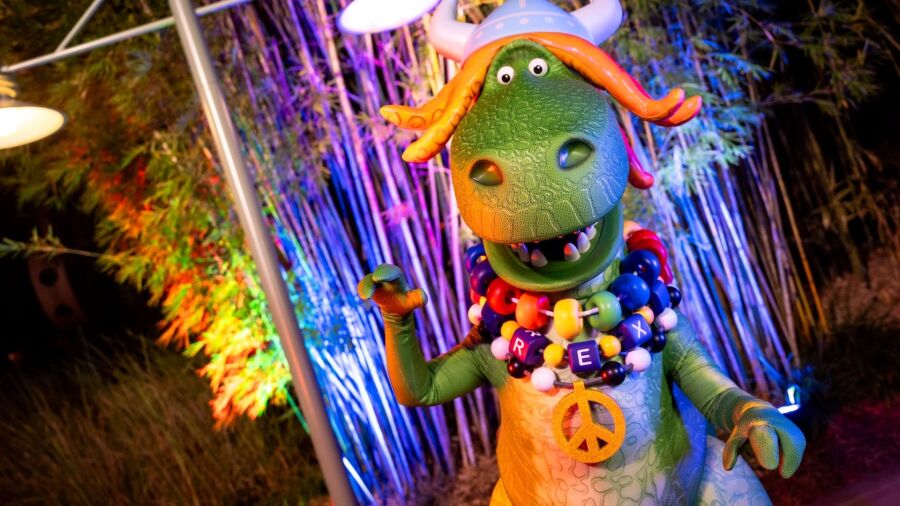 Partysaurus Rex from the Toy Story franchise at Jollywod Nights with a peace sign and beads saying 